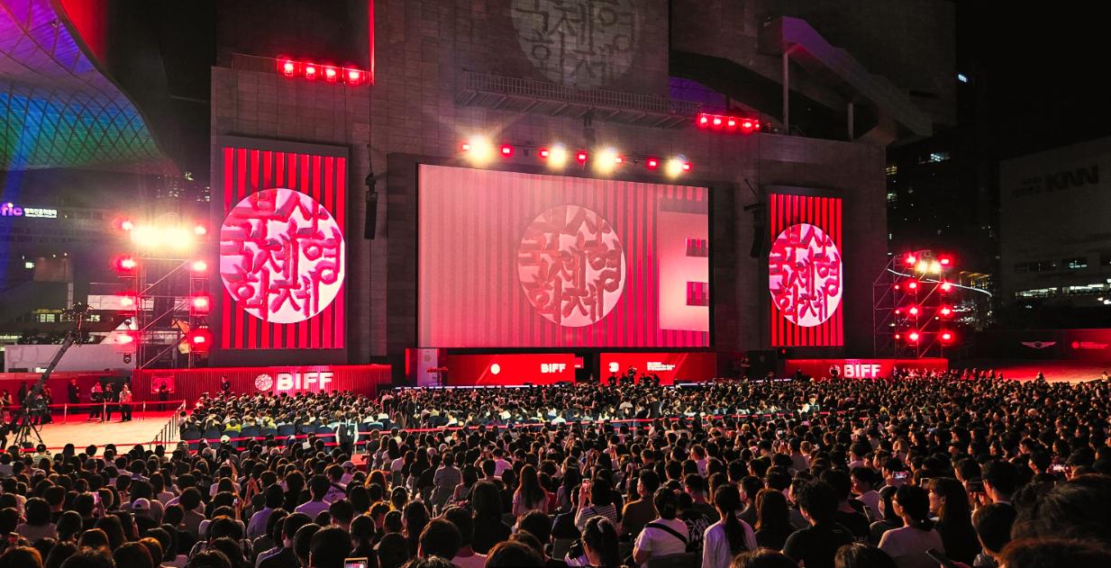 Audience and brightly lit stage at a previous Busan film festival