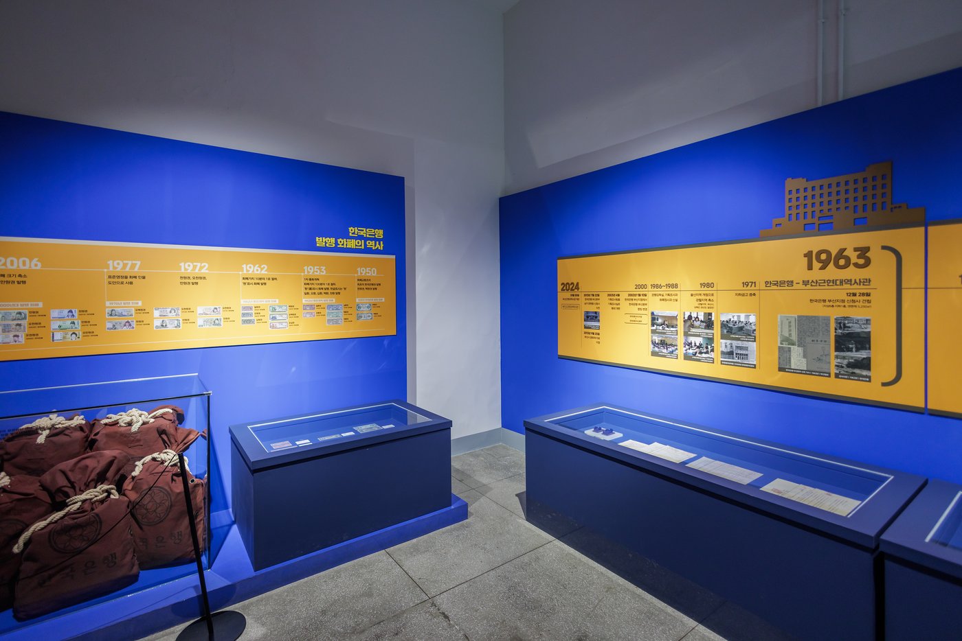 Blue and yellow museum displays about the Bank of Korea and currency history.