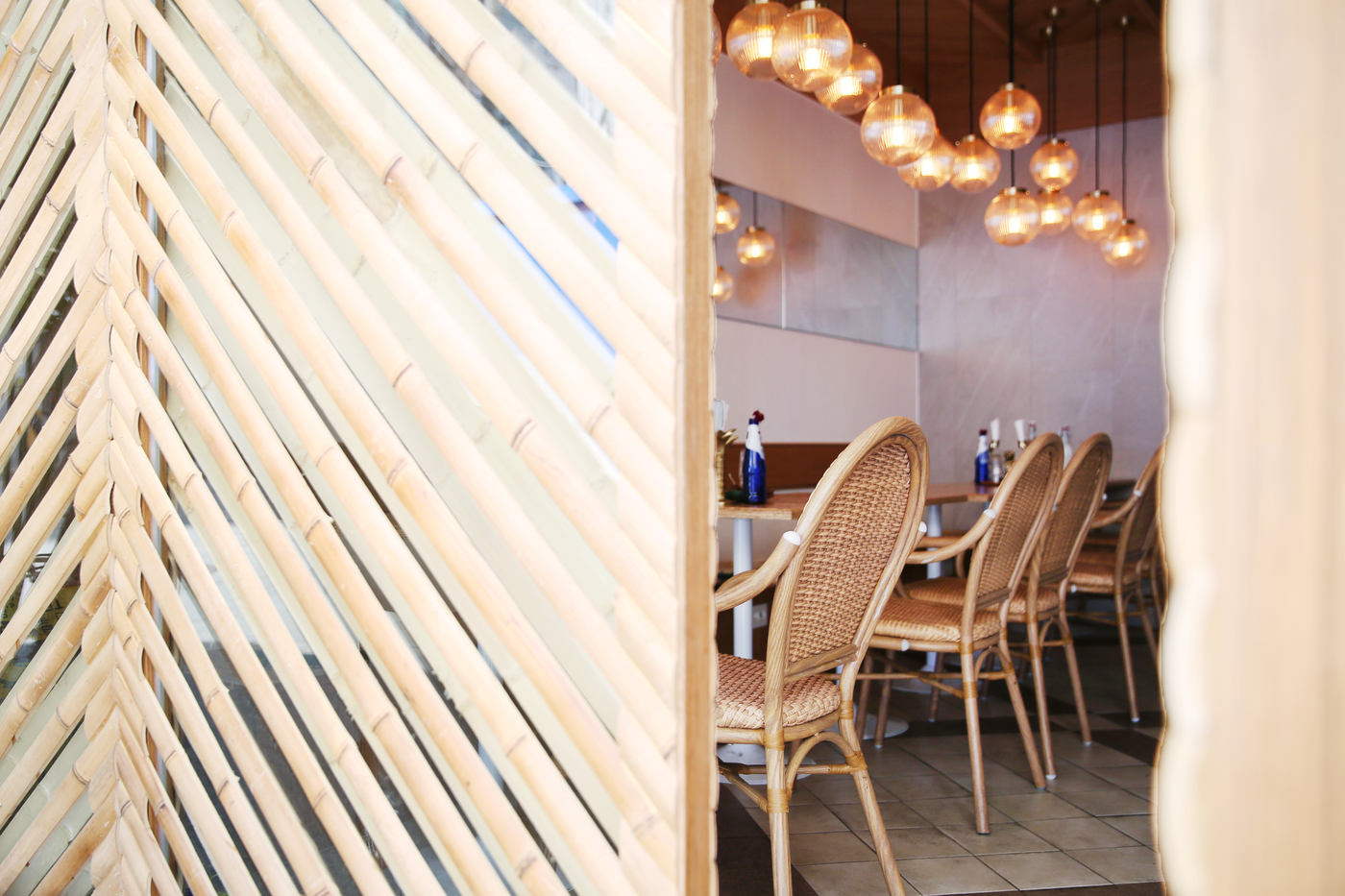 Warm pendant lights and woven chairs inside a Jeonpo cafe