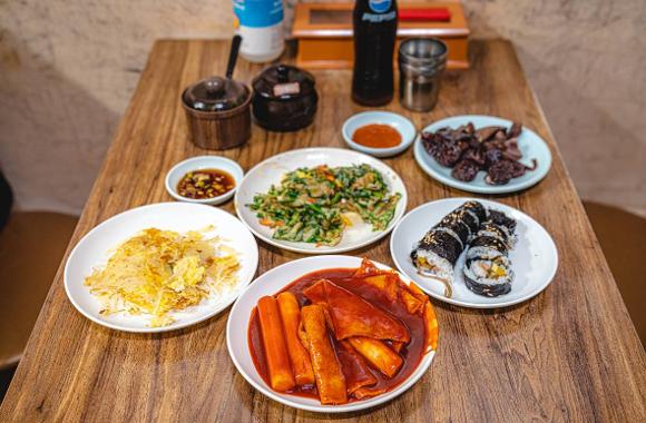 A table of Korean bunsik dishes including egg mandu and tteokbokki