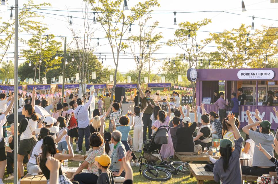 A host engaging seated visitors during an outdoor market activity