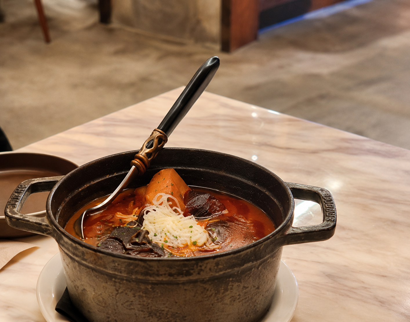 A pot of red stew with grated cheese at Or — AI-assisted edit