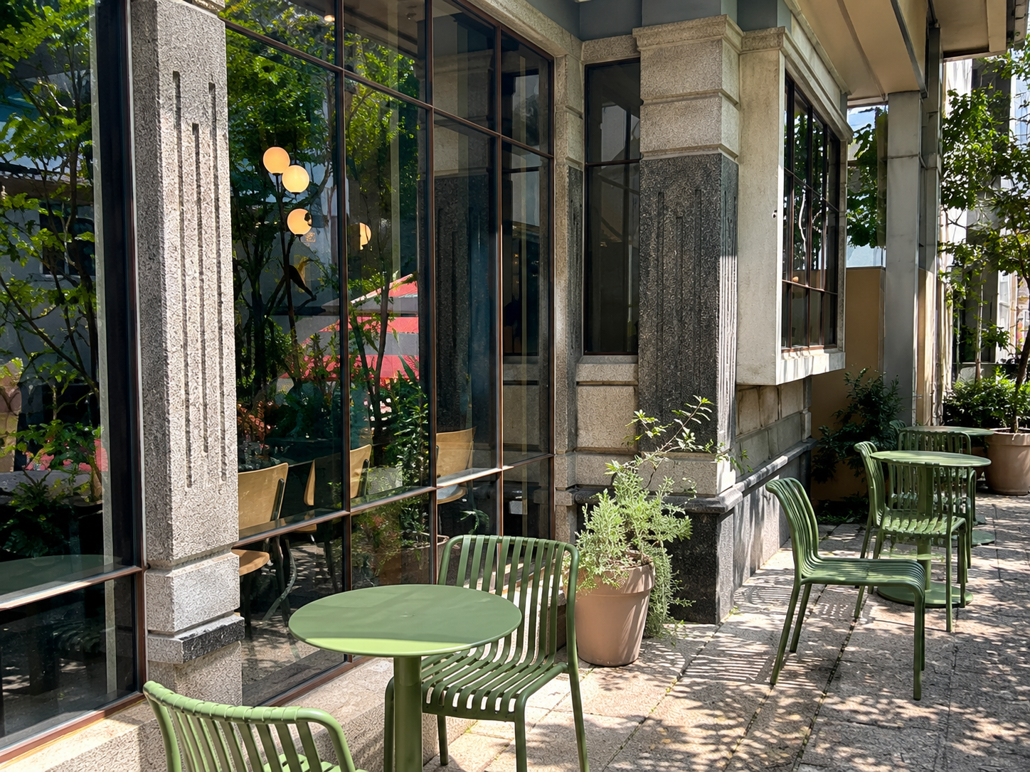 Green outdoor tables and chairs at Strut Coffee — AI-assisted edit
