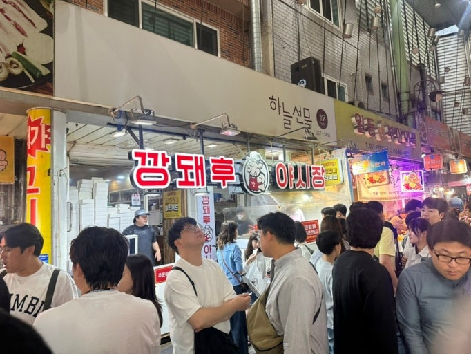 Customers outside the Kkang Dwae Hu storefront at Bupyeong Kkangtong Market