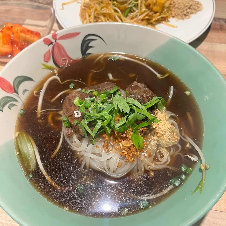 Beef rice noodles with herbs and a plate of pad Thai at Chang Thai Noodle