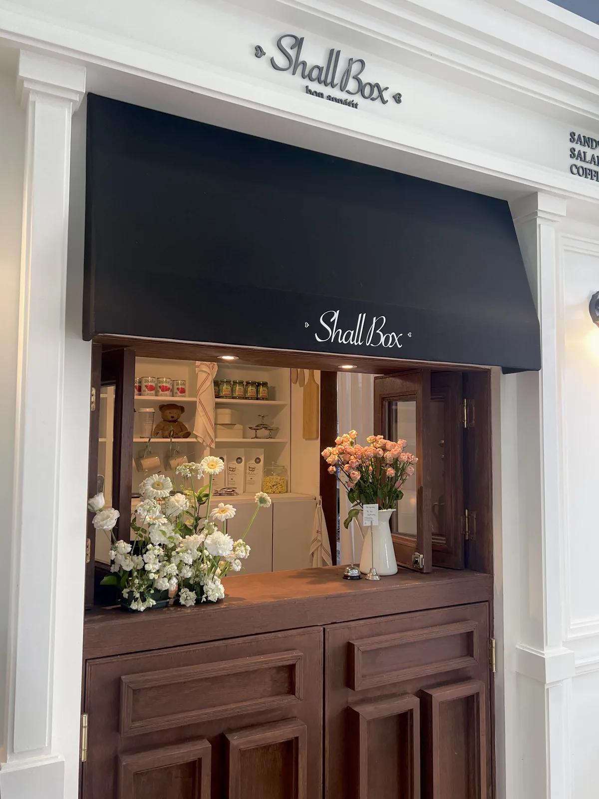 White facade and dark awning at the ShallBox main store in Busan