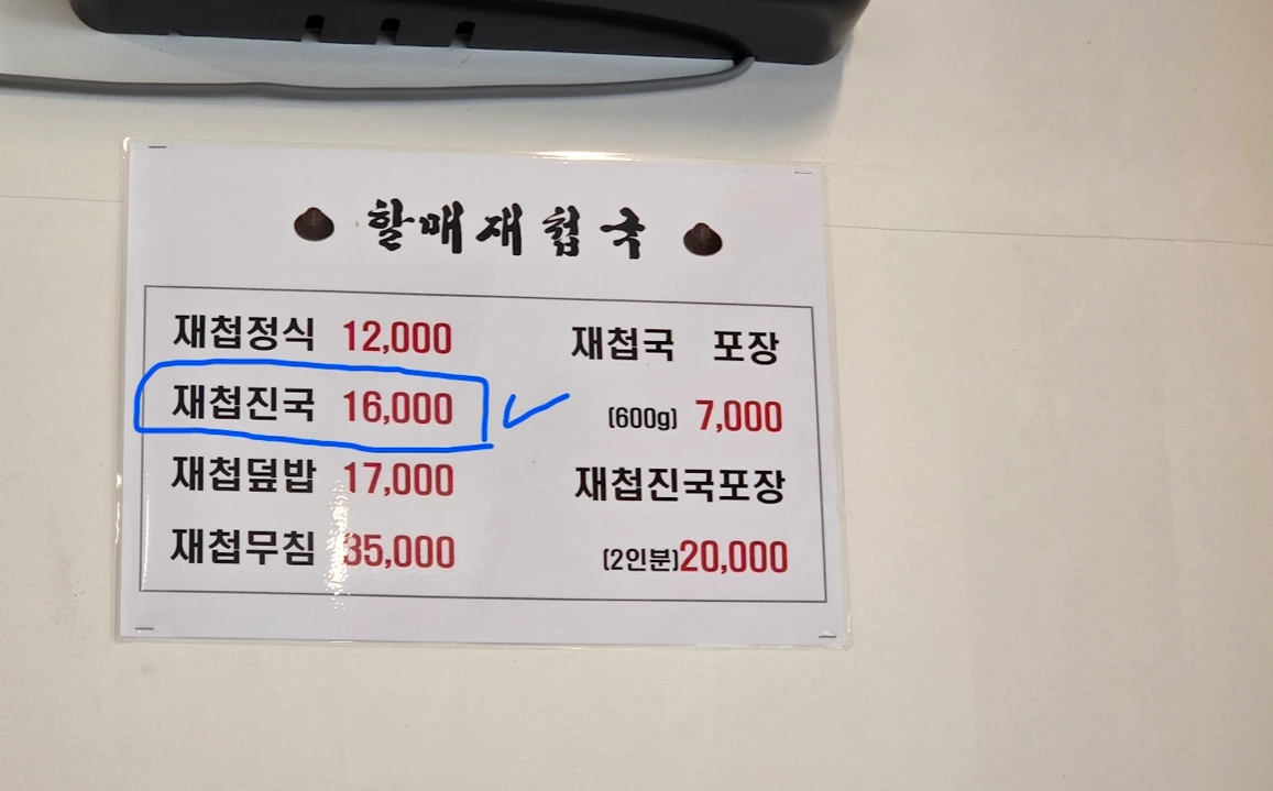A Korean menu board at Halmae Jaecheopguk, with the richer clam-soup option circled in blue.
