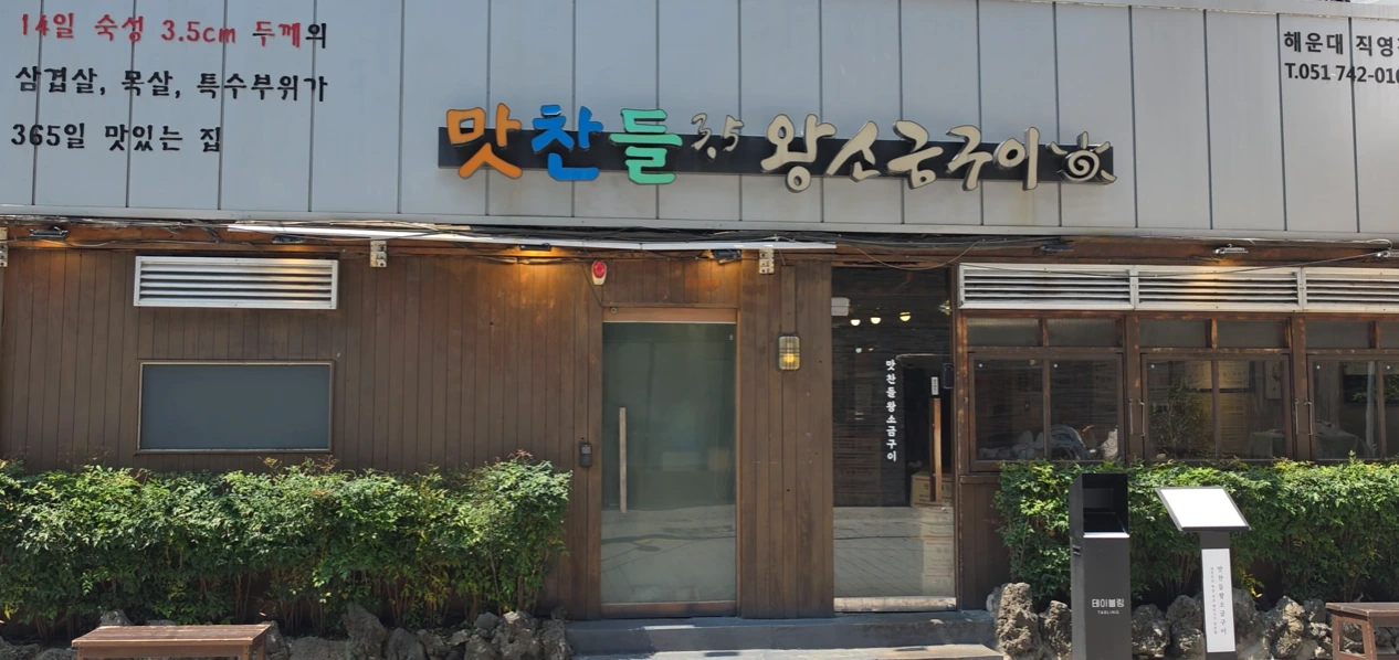Wood-fronted Matchandeul Haeundae restaurant with colorful Korean lettering above the entrance.