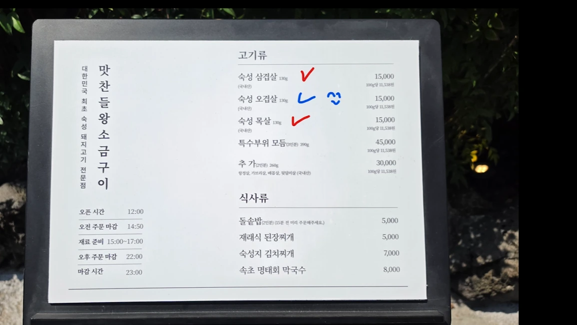 A Korean menu board from the source video listing pork cuts, meal options, prices and opening hours.
