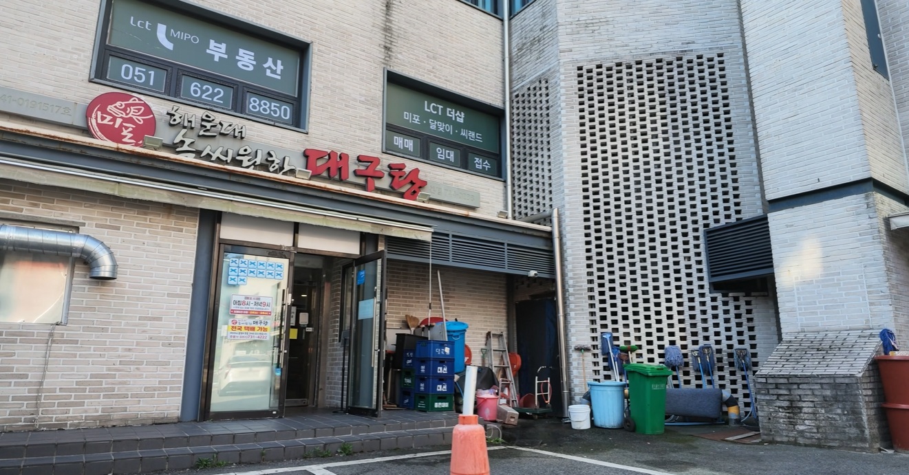 The entrance to Sok Ssiwonhan Daegutang, with its Korean restaurant sign and large red lettering for cod soup.