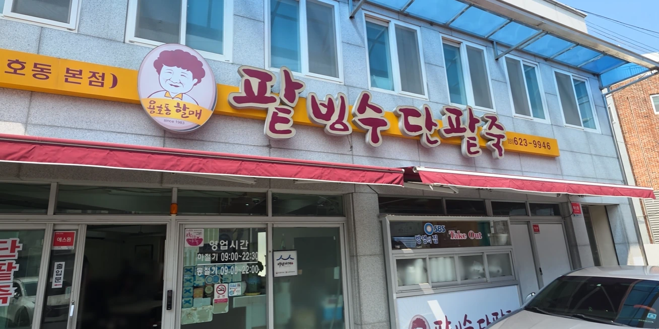 The storefront of Yongho-dong Halmae Patbingsu Danpatjuk with a grandmother logo and large Korean lettering.